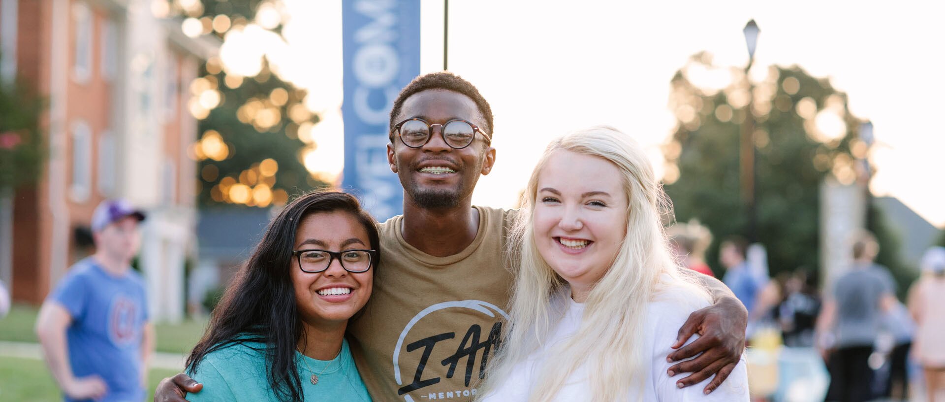 three students smiling at camera oustside