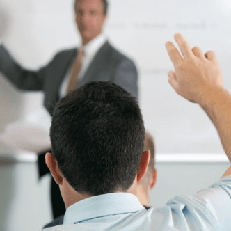 student raising hand in business class