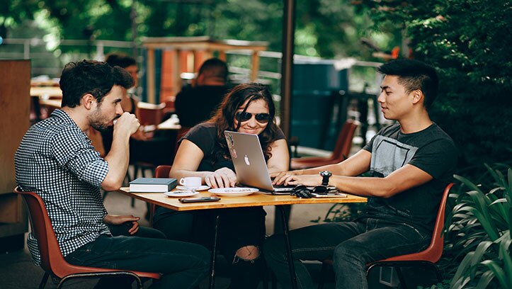 people gathered around laptop on table