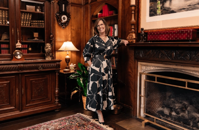 Leah Clevenger standing by a fireplace