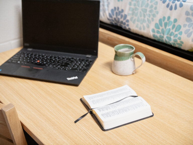 Boulevard Community Residence Halls desk with laptop, cup, and bible