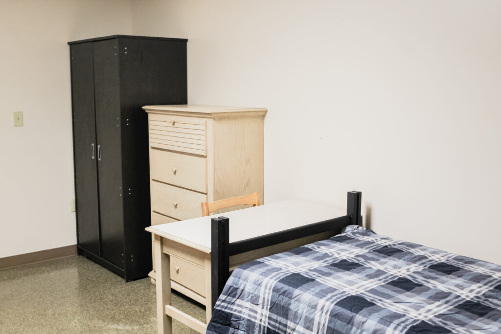 Village Basement Community Residence Halls bedroom with bed, cabinet, and closet