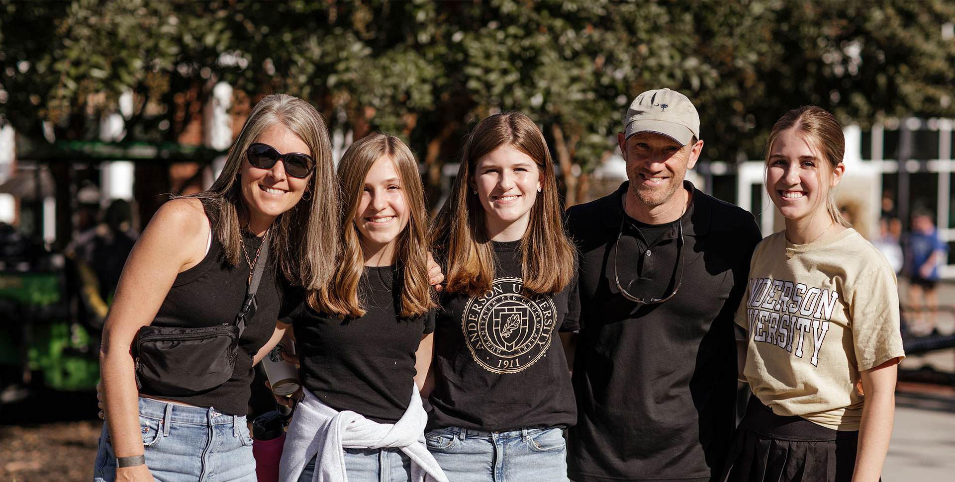 Family of Alumni in front of Oak Tree