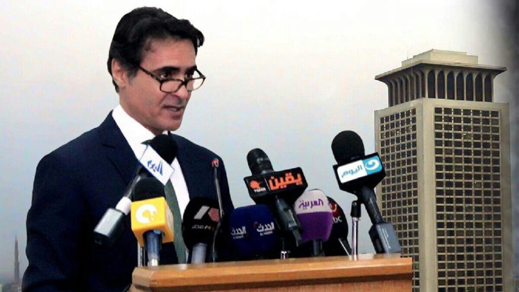 Dr. Elnakib speaking at a podium of microphones