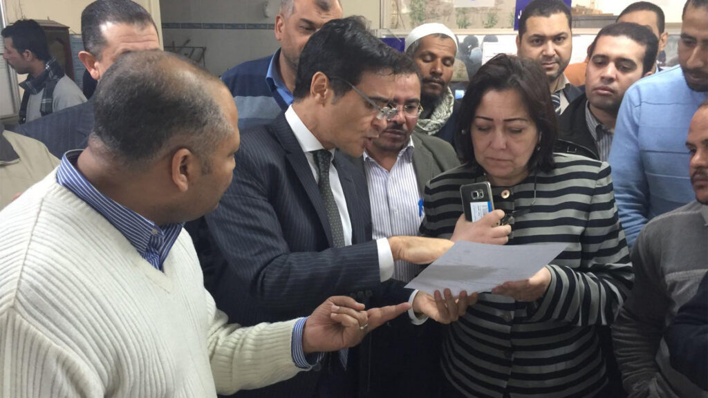 Dr. Elnakib surrounded by a group of people speaking