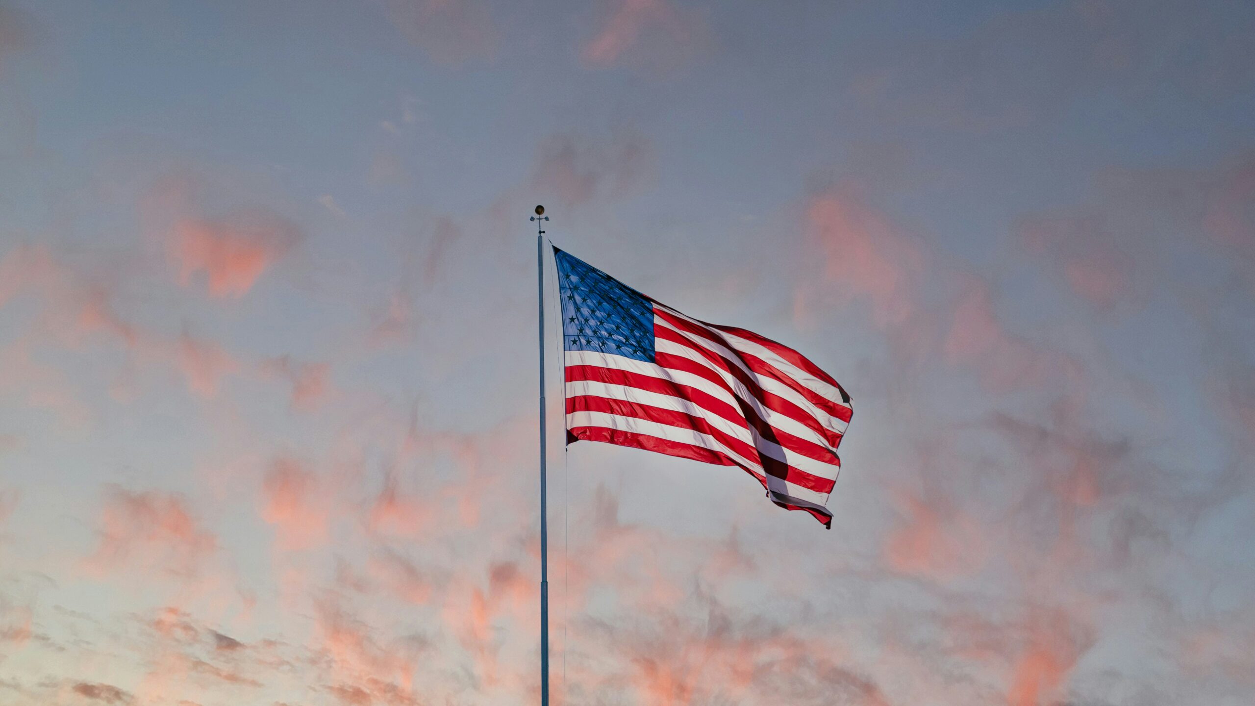 American flag waving against a blue sky